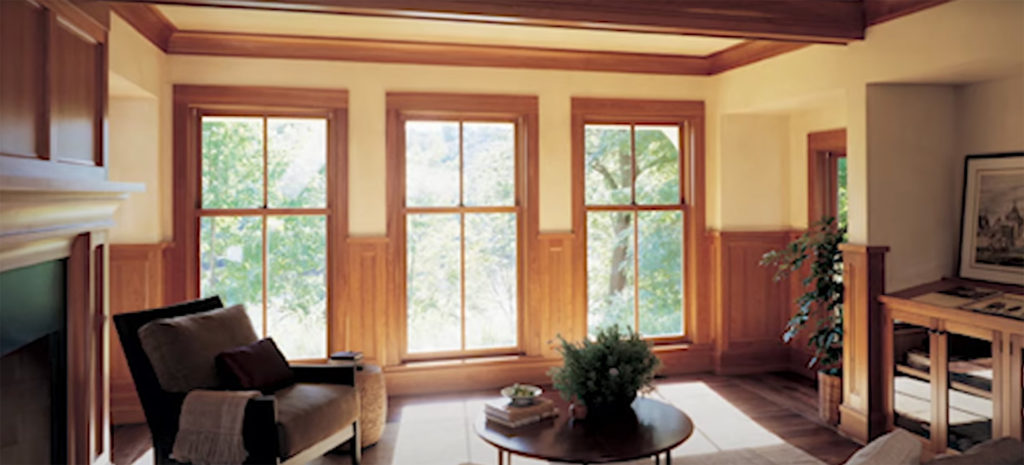 Cozy living room with wood paneling and Marvin Double Hung Windows