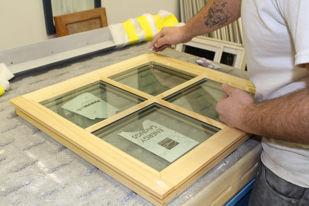 Close up of man finishing the wooden frame of a square window