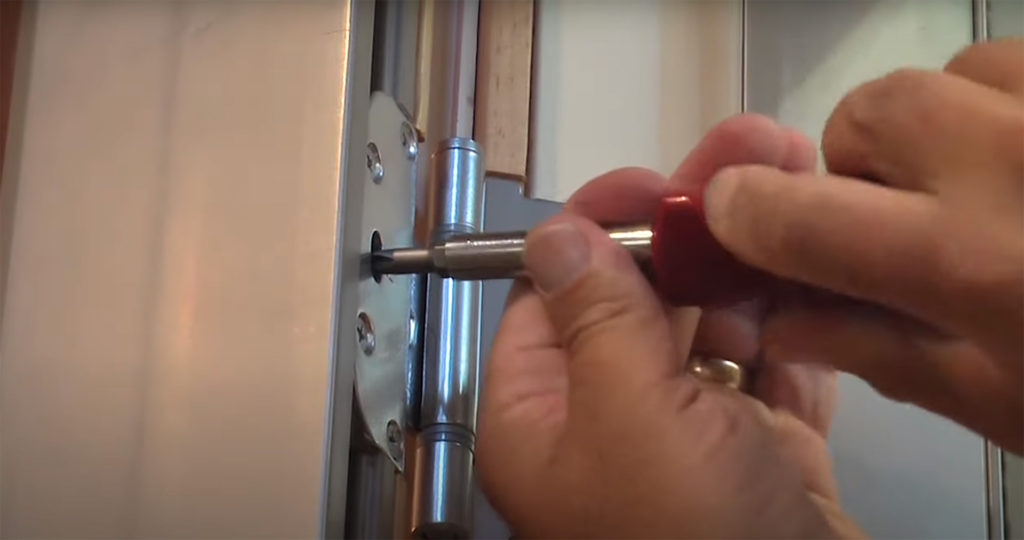 A man's hands demonstrating how to adjust integrity from Marvin Door Hinges
