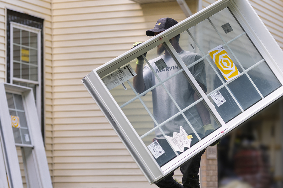 Carpenter carrying Marvin branded window ready for installation